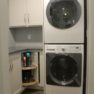 Small traditional l-shaped separated utility room in Other with shaker cabinets, engineered stone countertops, vinyl flooring, brown floors, blue worktops, grey cabinets, blue walls and a stacked washer and dryer.