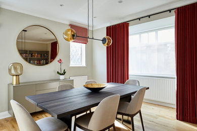 Design ideas for a medium sized traditional enclosed dining room in London with no fireplace, grey walls and light hardwood flooring.