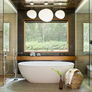 Aménagement d'une salle de bain principale asiatique avec des portes de placard en bois brun, une baignoire indépendante, une douche d'angle, un WC à poser et un carrelage beige.