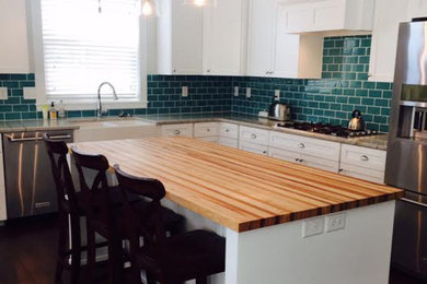 Photo of a large country single-wall open plan kitchen in Philadelphia with a farmhouse sink, beaded inset cabinets, white cabinets, wood benchtops, green splashback, ceramic splashback, stainless steel appliances, dark hardwood floors, with island, brown floor and multi-coloured benchtop.