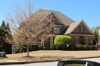 Inspiration for a mid-sized timeless red two-story brick house exterior remodel in Atlanta with a hip roof and a shingle roof