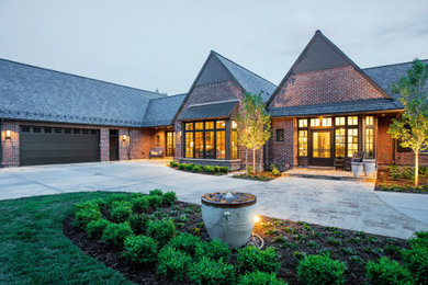 Cette photo montre une très grande façade de maison multicolore chic en brique à deux étages et plus avec un toit à deux pans et un toit gris.
