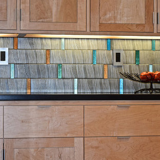 Cette photo montre une grande arrière-cuisine linéaire moderne avec un placard à porte plane, des portes de placard en bois brun, aucun îlot, un évier posé, un plan de travail en granite, une crédence grise, une crédence en carreau de ciment, un électroménager en acier inoxydable et un sol en bois brun.