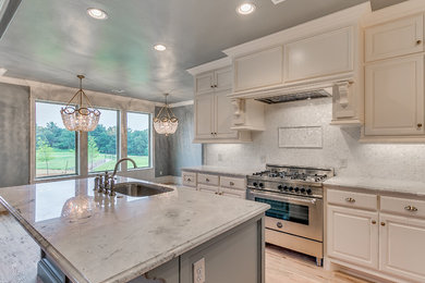 Eat-in kitchen - large contemporary light wood floor eat-in kitchen idea in Oklahoma City with white backsplash, mosaic tile backsplash, a drop-in sink, stainless steel appliances and an island