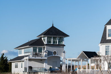 Example of a large beach style white three-story wood house exterior design in Bridgeport with a hip roof and a shingle roof