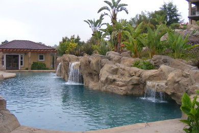 Example of a large tuscan backyard stamped concrete and custom-shaped natural pool fountain design in Orange County