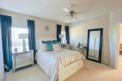 Diseño de dormitorio principal tropical de tamaño medio con paredes beige, moqueta y suelo beige