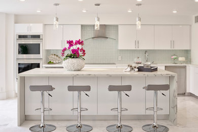 Design ideas for a large contemporary u-shaped open plan kitchen in Miami with a drop-in sink, glass-front cabinets, white cabinets, quartzite benchtops, white splashback, glass tile splashback, stainless steel appliances, marble floors, with island, grey floor and grey benchtop.