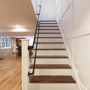 Photo of a large industrial walk-out basement in Chicago with blue walls, laminate floors, a standard fireplace, a wooden fireplace surround and brown floors.