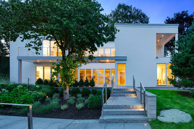 Large trendy white two-story stucco exterior home photo in Boston