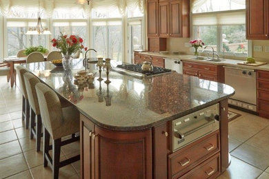 Photo of an expansive traditional l-shaped eat-in kitchen in Other with a double-bowl sink, raised-panel cabinets, medium wood cabinets, granite benchtops, stainless steel appliances, ceramic floors and with island.