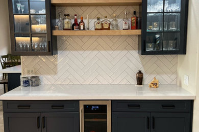 Dry bar - huge modern single-wall dry bar idea in Phoenix with no sink, glass-front cabinets, blue cabinets, quartzite countertops, white backsplash, subway tile backsplash and white countertops