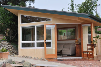 Small contemporary beige one-story stucco exterior home idea in San Luis Obispo with a metal roof