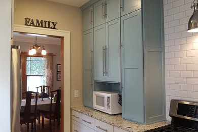 Example of a small arts and crafts galley light wood floor and brown floor eat-in kitchen design in Minneapolis with an undermount sink, flat-panel cabinets, white cabinets, granite countertops, white backsplash, subway tile backsplash and stainless steel appliances