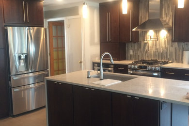 Inspiration for a modern l-shaped ceramic tile eat-in kitchen remodel in New York with an undermount sink, flat-panel cabinets, dark wood cabinets, marble countertops, multicolored backsplash, matchstick tile backsplash, stainless steel appliances and an island