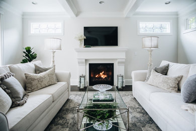 Inspiration for a mid-sized transitional enclosed living room in Vancouver with white walls, dark hardwood floors, a standard fireplace, a concrete fireplace surround and a wall-mounted tv.