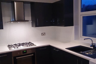 Modern kitchen in Essex with a double-bowl sink and white splashback.