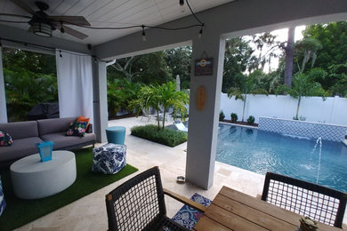 Patio - mid-sized modern backyard stone patio idea in Tampa with a roof extension