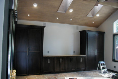 Foto de sala de manualidades clásica grande sin chimenea con paredes blancas, suelo de baldosas de porcelana, escritorio empotrado y suelo gris