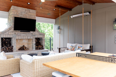 Example of a mid-sized backyard stamped concrete patio design in St Louis with a fireplace and a roof extension