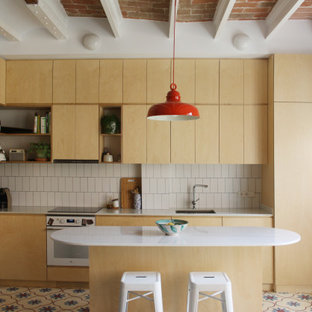 Ejemplo de cocina mediterránea con fregadero bajoencimera, armarios con paneles lisos, puertas de armario de madera clara, salpicadero blanco, electrodomésticos blancos, una isla, suelo multicolor y encimeras blancas