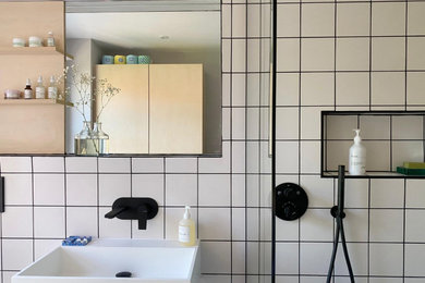 Scandinavian family bathroom in Other with a walk-in shower, white tiles, ceramic tiles, white walls, concrete flooring, grey floors, an open shower and a single sink.