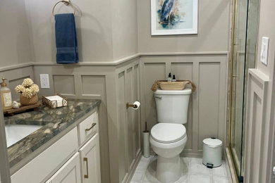 Example of a mid-sized minimalist porcelain tile, white floor, single-sink and wainscoting bathroom design in Dallas with shaker cabinets, white cabinets, a two-piece toilet, gray walls, an undermount sink, quartzite countertops, brown countertops, a niche and a built-in vanity