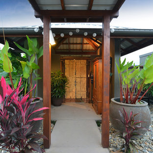 Design ideas for a tropical front door in Cairns with concrete floors, a double front door, a yellow front door and grey floor.