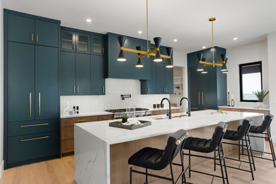 Example of a large trendy l-shaped open concept kitchen design in Denver with an undermount sink, flat-panel cabinets, green cabinets, white backsplash, paneled appliances, an island and white countertops