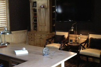 Ejemplo de despacho clásico renovado grande sin chimenea con paredes negras, suelo de madera clara, escritorio empotrado y suelo marrón