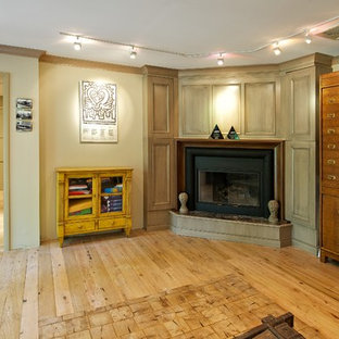 Photo of a large modern study in Philadelphia with beige walls, light hardwood flooring, a corner fireplace, a plastered fireplace surround and a freestanding desk.