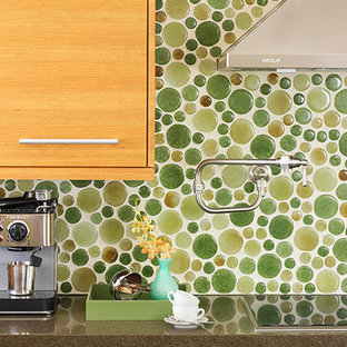 Design ideas for an expansive eclectic single-wall kitchen pantry in Los Angeles with a submerged sink, flat-panel cabinets, light wood cabinets, engineered stone countertops, green splashback, glass tiled splashback, black appliances, medium hardwood flooring and no island.
