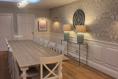 This is an example of a large classic kitchen/dining room in West Midlands with grey walls, medium hardwood flooring, brown floors, wallpapered walls and feature lighting.