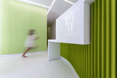 Ejemplo de recibidores y pasillos actuales de tamaño medio con paredes verdes, suelo vinílico y suelo blanco