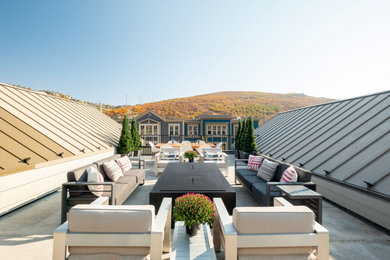 Inspiration for a large modern concrete patio remodel in Salt Lake City with a fire pit and a roof extension