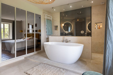 Inspiration pour une grande salle de bain principale et beige et blanche design avec un placard à porte affleurante, des portes de placard blanches, une baignoire indépendante, une douche double, un carrelage beige, du carrelage en pierre calcaire, un mur beige, un sol en calcaire, une vasque, un plan de toilette en bois, un sol beige, aucune cabine, un plan de toilette beige, une fenêtre, meuble double vasque, meuble-lavabo suspendu et un mur en pierre.