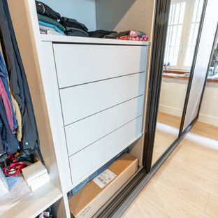 Inspiration pour un grand dressing traditionnel neutre avec un placard à porte affleurante, des portes de placard grises, un sol en bois clair, un sol beige et un plafond en poutres apparentes.