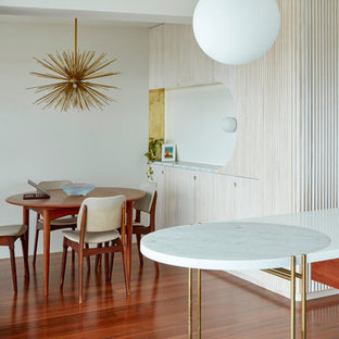 Свежая идея для дизайна: маленькая гостиная-столовая в стиле ретро с белыми стенами, паркетным полом среднего тона и коричневым полом - отличное фото интерьера