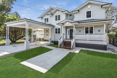 Mid-sized traditional two-storey grey house exterior in Brisbane with concrete fiberboard siding, a gable roof and a metal roof.