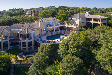 Inspiration for a large mediterranean backyard deck remodel in Austin with a roof extension