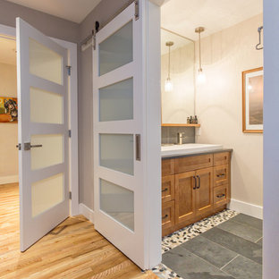 Esempio di una piccola stanza da bagno padronale minimalista con ante in stile shaker, ante in legno bruno, vasca da incasso, doccia alcova, WC a due pezzi, piastrelle grigie, piastrelle in pietra, pareti gialle, pavimento in gres porcellanato, lavabo rettangolare, top in quarzo composito, pavimento grigio e doccia aperta