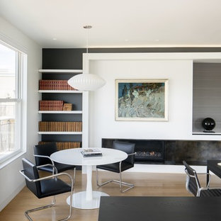 Medium sized modern home office and library in Denver with white walls, light hardwood flooring, a ribbon fireplace, a plastered fireplace surround, a built-in desk and beige floors.