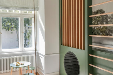 Design ideas for a mid-sized traditional kids' playroom for kids 4-10 years old and boys in Dresden with green walls, carpet, grey floor and wallpaper.
