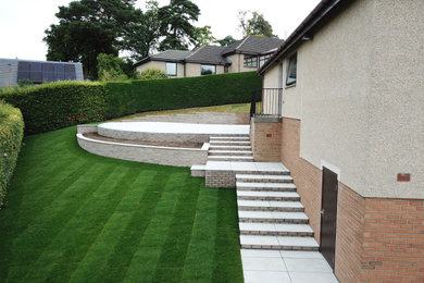Design ideas for a contemporary sloped garden in Other with natural stone paving.