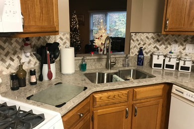 Inspiration for a small timeless l-shaped enclosed kitchen remodel in Other with an undermount sink, recessed-panel cabinets, medium tone wood cabinets, quartzite countertops, beige backsplash, porcelain backsplash, white appliances, an island and beige countertops