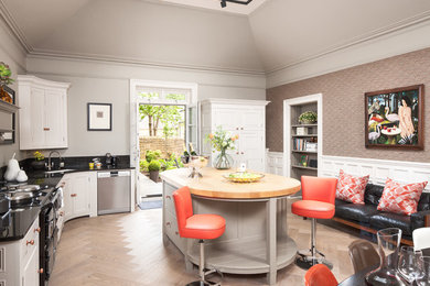 Large transitional l-shaped kitchen photo in Edinburgh with an undermount sink, recessed-panel cabinets, gray cabinets, stainless steel appliances, an island and black countertops