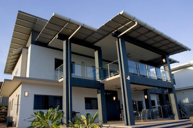 This is an example of a tropical two-storey concrete white exterior in Darwin with a flat roof.