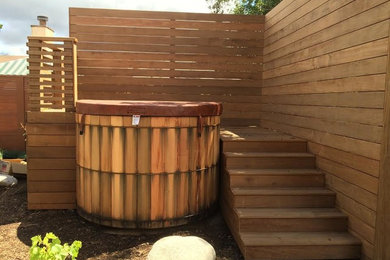Inspiration for a small arts and crafts backyard round aboveground pool in San Diego with a hot tub and decking.