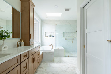 Bathroom - large transitional master white tile and porcelain tile porcelain tile, white floor and double-sink bathroom idea in DC Metro with shaker cabinets, medium tone wood cabinets, beige walls, an undermount sink, quartzite countertops, a hinged shower door, white countertops, a niche and a built-in vanity