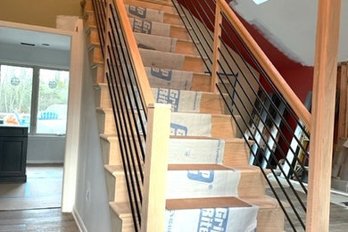 Ejemplo de escalera recta minimalista de tamaño medio con escalones de madera, contrahuellas de madera y barandilla de varios materiales